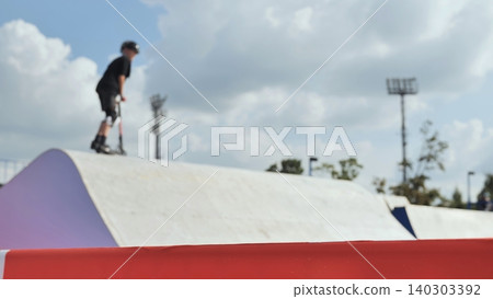 Young rider practicing extreme sport on a scooter at skate park Young rider practicing extreme sport on a scooter at skate park 140303392