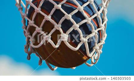 Basketball entering the hoop during a sunny sports day Basketball entering the hoop during a sunny sports day 140303503
