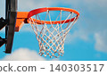 An orange basketball hoop with a white net against a vibrant blue sky on a sunny day 140303517