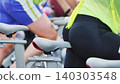 Rear view of a fit woman on an exercise bike during a cardio workout session in a gym 140303548