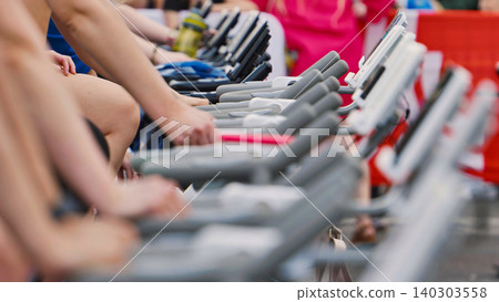 Athletes Competing on Stationary Bikes at Sports Event 140303558