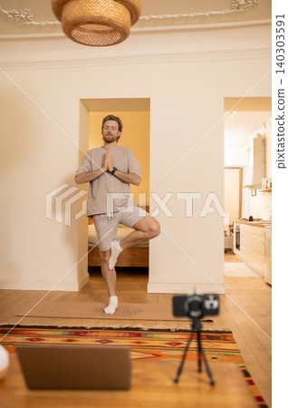 Young caucasian doing yoga and standing in a tree pose Young caucasian doing yoga and standing in a tree pose 140303591