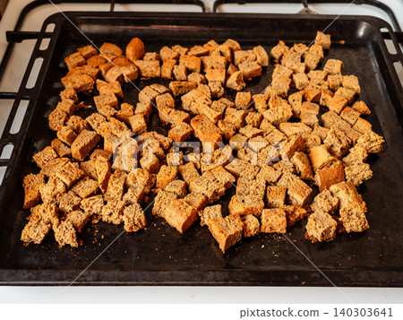 slices of rye bread cut into cubes on oven tray 140303641