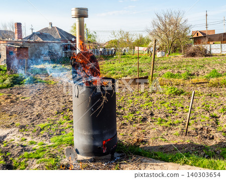 burning garbage in barrel with chimney in garden burning garbage in barrel with chimney in garden 140303654
