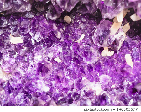 rough amethyst crystals in geode close-up 140303677