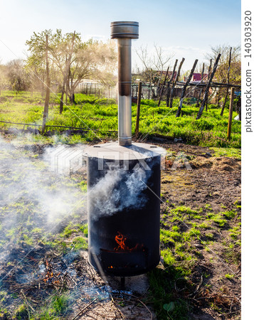 trash burns in waste incinerator barrel in garden trash burns in waste incinerator barrel in garden 140303920