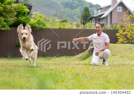 Senior man playing with a dog 140304482