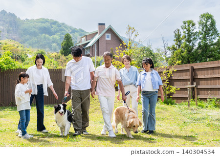 A three-generation family walking their dog A three-generation family walking their dog 140304534