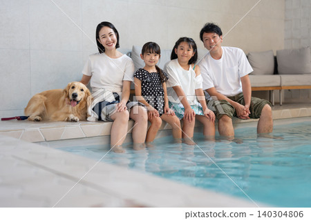 一家人在泳池裡和他們的狗玩耍 一家人在泳池裡和他們的狗玩耍 140304806