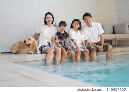 一家人在泳池裡和他們的狗玩耍 一家人在泳池裡和他們的狗玩耍 140304807