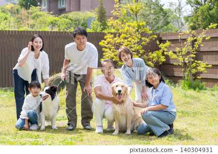 A three-generation family playing with their dog in the yard A three-generation family playing with their dog in the yard 140304931