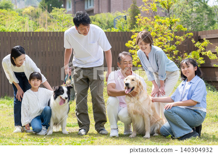 一家三代人在院子裡和他們的狗玩耍 一家三代人在院子裡和他們的狗玩耍 140304932
