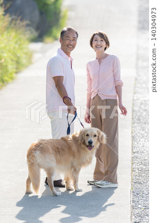 Senior couple walking a dog Senior couple walking a dog 140304973