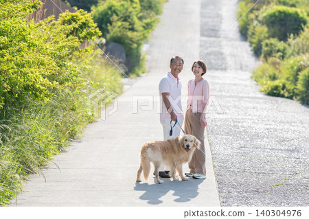 Senior couple walking a dog Senior couple walking a dog 140304976