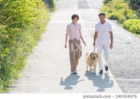 Senior couple walking a dog Senior couple walking a dog 140304979