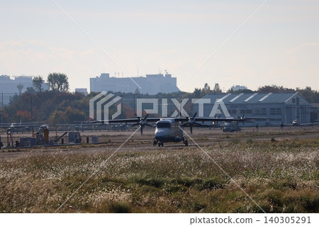 A small propeller passenger plane prepares for takeoff on the runway in the early morning. 140305291