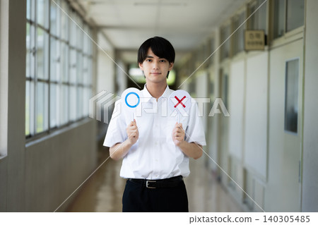 一名男學生在走廊上舉著牌子 140305485