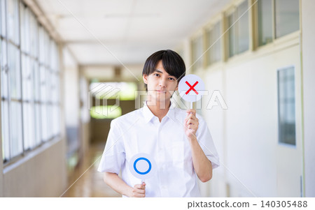 一名男學生在學校走廊舉著標語牌 140305488