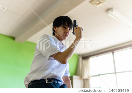 A man holding a gun in a classroom. A man holding a gun in a classroom. 140305489