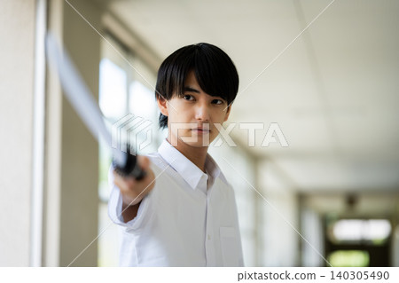 A male student holding a sword. 140305490