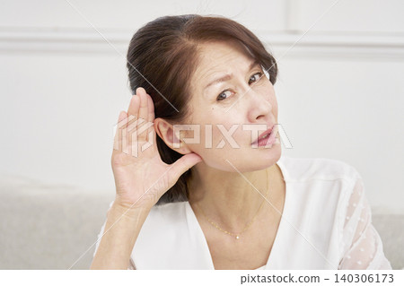 Hearing-impaired senior woman in the living room Hearing-impaired senior woman in the living room 140306173
