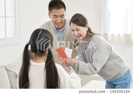 Grandmother and grandfather giving New Year's money to their grandchild 140306184