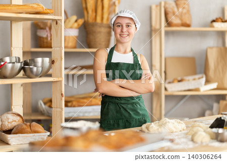Teenage girl standing in bakehouse, ready to start baking Teenage girl standing in bakehouse, ready to start baking 140306264