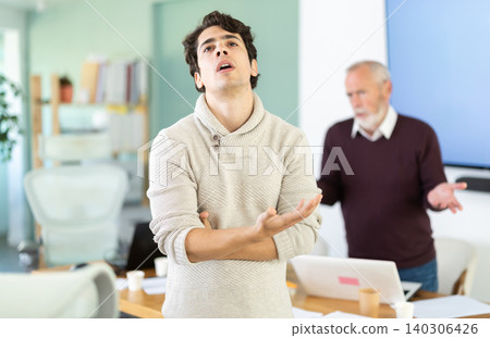 Elderly man scolds young man in office Elderly man scolds young man in office 140306426