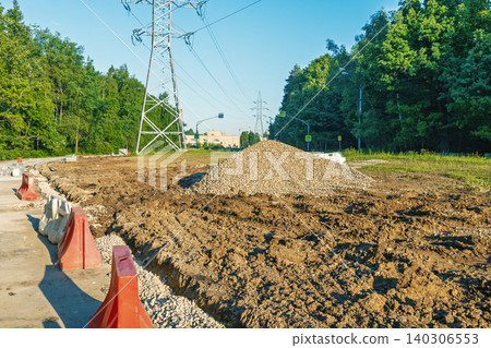 Rural road construction with gravel pile and power lines Rural road construction with gravel pile and power lines 140306553