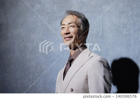 黑色背景上的一位身著西裝的老年男子的肖像 140306576