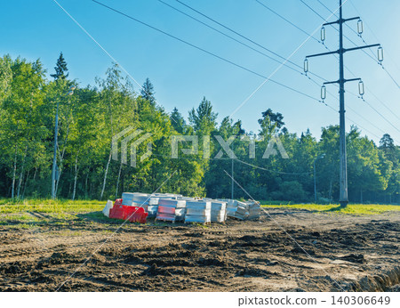 Construction materials stacked near power line in forest clearing 140306649