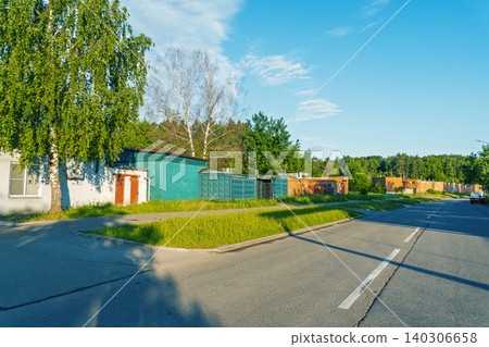 Row of colorful metal garages along a suburban roadside with trees Row of colorful metal garages along a suburban roadside with trees 140306658