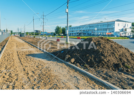 Urban street under construction with soil piles and curb installation Urban street under construction with soil piles and curb installation 140306694