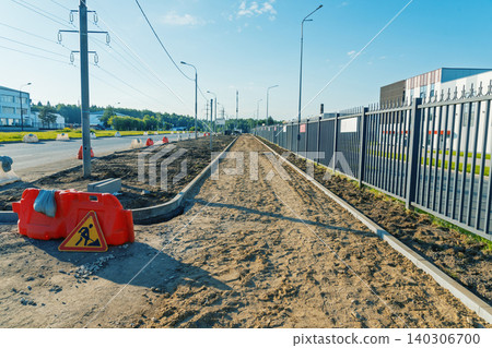 Urban sidewalk construction site with metal fence and road signs 140306700
