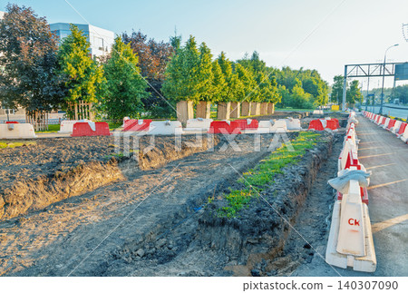 Urban street excavation with safety barriers and tree-lined sidewalk Urban street excavation with safety barriers and tree-lined sidewalk 140307090