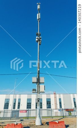 Telecommunications pole with mounted equipment against clear blue sky Telecommunications pole with mounted equipment against clear blue sky 140307219