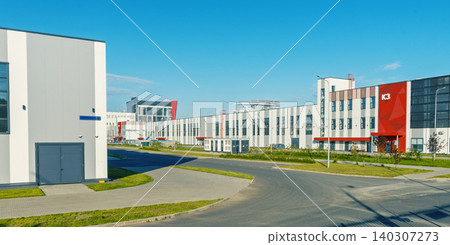 Modern industrial complex with low-rise warehouses and office buildings under clear blue sky 140307273