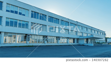 Long low industrial office building with air conditioning units and paved forecourt at sunrise Long low industrial office building with air conditioning units and paved forecourt at sunrise 140307282