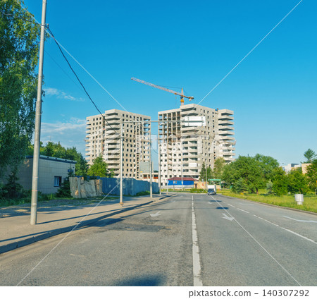 Unfinished high-rise apartment buildings under construction by roadside Unfinished high-rise apartment buildings under construction by roadside 140307292