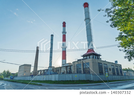 Industrial power plant with tall smoke stacks and brick boiler house at sunrise Industrial power plant with tall smoke stacks and brick boiler house at sunrise 140307332