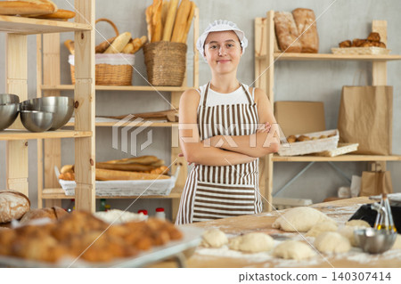 Teenage girl standing in bakehouse, ready to start baking Teenage girl standing in bakehouse, ready to start baking 140307414
