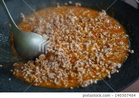 看起來很美味的肉末和醬汁正在煎鍋裡翻炒。 看起來很美味的肉末和醬汁正在煎鍋裡翻炒。 140307484