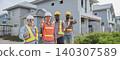 Diverse construction workers showing thumbs up in front of modern housing site 140307589