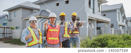 Diverse construction workers showing thumbs up in front of modern housing site Diverse construction workers showing thumbs up in front of modern housing site 140307589
