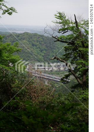 從綠樹環繞的山頂上，可以俯瞰鬱鬱蔥蔥的山脈和公路交叉口。 140307614