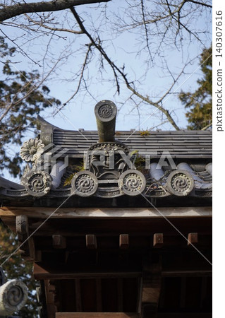 這座歷史悠久的寺廟的屋頂上有長滿青苔的滴水嘴獸和帶有三逗號紋章的瓦片。 這座歷史悠久的寺廟的屋頂上有長滿青苔的滴水嘴獸和帶有三逗號紋章的瓦片。 140307616