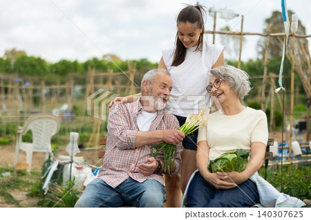 Grandparents relax after working on the farm and chatting with granddaughter Grandparents relax after working on the farm and chatting with granddaughter 140307625