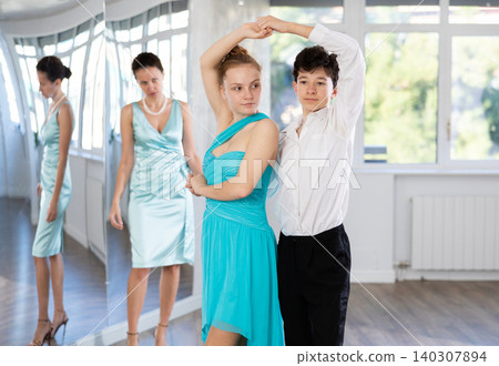 of teenagers in festive clothes learn to dance latin american dance Bachata in studio under the guidance of teacher of teenagers in festive clothes learn to dance latin american dance Bachata in studio under the guidance of teacher 140307894
