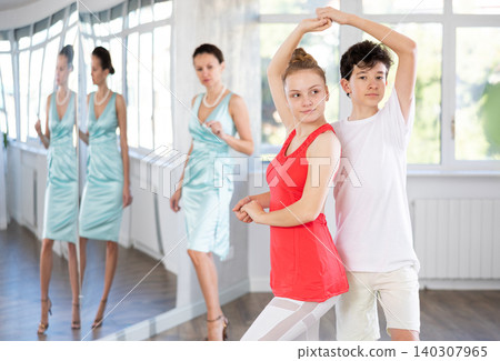 Adolescent dance duo, boy and girl, refining slow foxtrot with female coach Adolescent dance duo, boy and girl, refining slow foxtrot with female coach 140307965