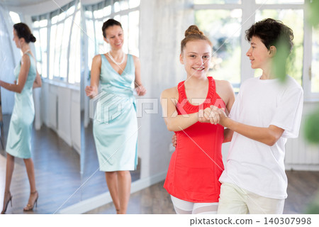 Teenage boy and girl performing waltz in pair during dance lesson 140307998